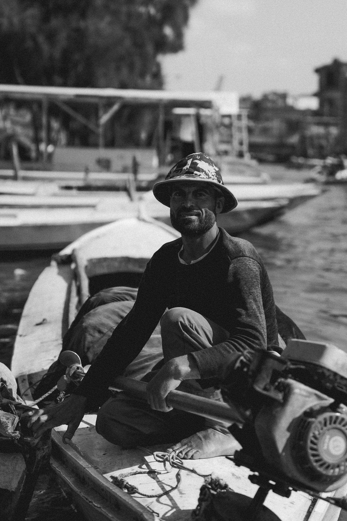 Black and white portrait of a local fisherman on a boat in Cairo, Egypt. Capturing daily life on the Nile.